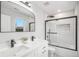 Bright bathroom featuring a double sink vanity, sleek fixtures, and black framed shower with modern white tile at 1990 Ulster St, Denver, CO 80220