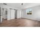 Spacious bedroom with wood floors, a sliding barn door closet, and a window offering natural light at 1990 Ulster St, Denver, CO 80220