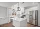 Modern kitchen with white cabinets, island, and stainless steel appliances, offering a sleek design at 1990 Ulster St, Denver, CO 80220