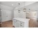 Spacious kitchen featuring a white island with light wood floors, modern pendant lights and plenty of room to move at 1990 Ulster St, Denver, CO 80220