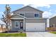 Two-story home featuring a large two car garage, gray siding, and manicured front lawn at 7220 Big Thompson Ct, Frederick, CO 80530