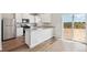 Bright kitchen with stainless steel appliances, wood floors, white cabinets, and breakfast bar at 7220 Big Thompson Ct, Frederick, CO 80530