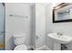 Powder room featuring a white toilet, pedestal sink and vanity mirror at 4570 E Yale Ave # 706, Denver, CO 80222