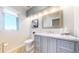 Bathroom with gray vanity, silver framed mirror, and tile flooring at 6260 Rain Dance Trl, Littleton, CO 80125