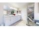 Bright bathroom with a double vanity, large mirrors, and marble shower at 6260 Rain Dance Trl, Littleton, CO 80125