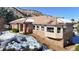 Charming home exterior with stone accents, snow, and a well-maintained yard at 6260 Rain Dance Trl, Littleton, CO 80125
