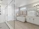 Bright bathroom featuring a glass-enclosed shower, modern soaking tub, and neutral tile flooring at 5835 Chester Way, Denver, CO 80238