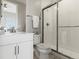 Clean bathroom featuring a modern vanity, a toilet, and a glass-enclosed shower with white subway tile at 5835 Chester Way, Denver, CO 80238