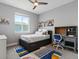Bright bedroom with a full-sized bed, a study desk, and a large window at 5835 Chester Way, Denver, CO 80238