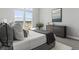 Relaxing bedroom featuring modern decor, a comfortable bed, and a large window providing scenic neighborhood views at 5835 Chester Way, Denver, CO 80238