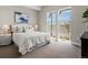 Comfortable bedroom with a white bed, plush pillows, and large windows offering expansive views and natural light at 5835 Chester Way, Denver, CO 80238
