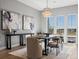 Elegant dining room with a modern chandelier, artwork, and scenic outdoor views through large windows at 5835 Chester Way, Denver, CO 80238