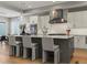 Stylish kitchen island with pendant lighting, seating, and a view of modern appliances and cabinets at 5835 Chester Way, Denver, CO 80238