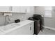 Bright laundry room features modern washer/dryer, white cabinets, and a sleek countertop with a stainless steel faucet at 5835 Chester Way, Denver, CO 80238