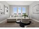 Stylish living room featuring modern decor, a plush white sofa, and ample natural light from three large windows at 5835 Chester Way, Denver, CO 80238