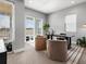 Bright home office with plush chairs, a modern desk, large windows, and neutral tones creates a serene workspace at 5835 Chester Way, Denver, CO 80238