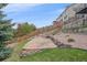 Beautiful backyard with stone patio, wooden fence and lush landscaping at 15887 W Ellsworth Ln, Golden, CO 80401
