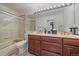 Bathroom featuring a double sink vanity and a glass shower with marble tile accents at 15887 W Ellsworth Ln, Golden, CO 80401