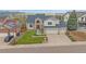 Beautiful two-story home with a well-manicured front yard, three car garage, and green landscaping at 15887 W Ellsworth Ln, Golden, CO 80401