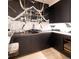 Luxurious bar area with unique stone accent wall, dark wood cabinetry, and beverage fridge at 40 Royal Ann Dr, Greenwood Village, CO 80111