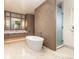 Luxurious bathroom with a standalone tub, elegant wood accents, and a frosted glass shower for relaxation at 40 Royal Ann Dr, Greenwood Village, CO 80111