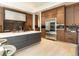 Gourmet kitchen boasts a large island, stainless steel appliances, and sleek wooden cabinetry for ample storage at 40 Royal Ann Dr, Greenwood Village, CO 80111