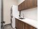 Efficient laundry area with stacked washer and dryer, cabinet storage, and modern sink at 40 Royal Ann Dr, Greenwood Village, CO 80111