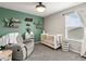Stylish Bedroom with an accent wall, crib, and a comfortable rocking chair at 1527 Biffle Ct, Berthoud, CO 80513