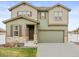 Charming two-story house with lush green lawn, attached garage, and covered front porch at 1527 Biffle Ct, Berthoud, CO 80513