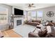 Cozy living room featuring a fireplace, large windows, and comfortable brown leather sectional sofa at 1527 Biffle Ct, Berthoud, CO 80513