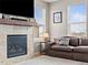Cozy living room featuring a fireplace, comfortable leather sofa, and natural light from bright windows at 1527 Biffle Ct, Berthoud, CO 80513