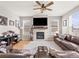 Inviting living room with stone fireplace, large TV, hardwood floors, and comfortable brown leather furniture at 1527 Biffle Ct, Berthoud, CO 80513