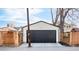 Exterior view of detached garage with black door and white siding, surrounded by fencing at 945 Jackson St, Denver, CO 80206