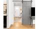 Hallway view featuring a stylish sliding door, wood floors, and access to other rooms in the house at 945 Jackson St, Denver, CO 80206