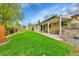 Expansive backyard featuring a lush green lawn and a covered patio perfect for outdoor relaxation at 460 S Taft St, Lakewood, CO 80228