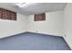 Spacious basement featuring blue carpet and white walls, with small window coverings at 460 S Taft St, Lakewood, CO 80228