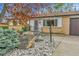 A well maintained home features a brick facade, decorative rock, and mature trees at 460 S Taft St, Lakewood, CO 80228