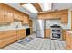 Updated kitchen with stainless steel appliances, wooden cabinets, and tiled floor at 460 S Taft St, Lakewood, CO 80228