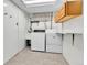 Functional laundry room with a utility sink, storage cabinets, and a washer/dryer setup at 460 S Taft St, Lakewood, CO 80228