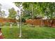 Green backyard features a garden bed, landscaping, lamp post, trees, and lawn at 840 Essex Dr, Denver, CO 80229