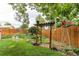 Backyard garden bed and landscaping with a wooden windmill and pergola at 840 Essex Dr, Denver, CO 80229