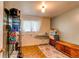 Bedroom with brick walls, wood floors, large window, shelf and a wooden trunk on an area rug at 840 Essex Dr, Denver, CO 80229