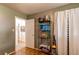 Bedroom view with green walls featuring storage shelf, wood floors, and access to other rooms at 840 Essex Dr, Denver, CO 80229