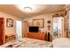 Bright bedroom with a dresser, television, and a glimpse into an adjoining bathroom at 840 Essex Dr, Denver, CO 80229