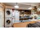 Practical kitchen design with stacked laundry units, dark wood cabinets, and countertop appliances at 840 Essex Dr, Denver, CO 80229