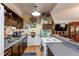 Functional kitchen layout with ample counter space, dark wood cabinets, and convenient appliances at 840 Essex Dr, Denver, CO 80229