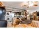 Open-concept living space featuring a brown sofa, wood floors, and kitchen appliances in the background at 840 Essex Dr, Denver, CO 80229