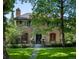 Brick home with a tile roof, mature trees, and a landscaped lawn at 559 N Williams St, Denver, CO 80218