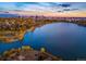 Beautiful aerial view of a serene lake and park with the city skyline silhouetted at sunset at 3520 W Conejos Pl # 11, Denver, CO 80204
