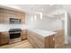 Modern kitchen boasting stainless steel appliances, wood cabinetry, and a central island for meal preparation at 3520 W Conejos Pl # 11, Denver, CO 80204